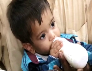 Nine-month-old boy clasping his bottle appears in court accused of planning murder in Pakistan